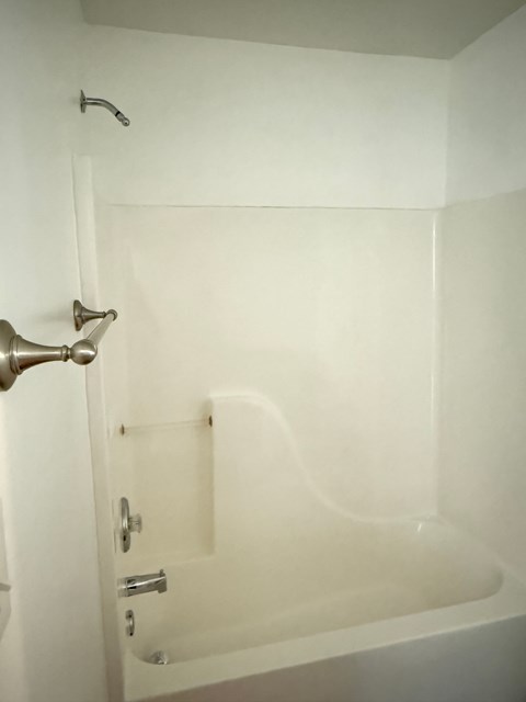 A white bathroom with a tub and shower.