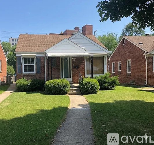 A brick house with a white porch and a green door.