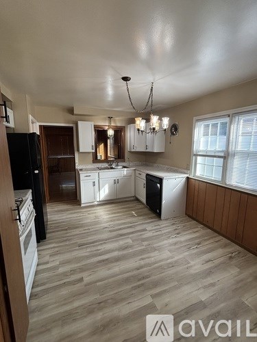 A kitchen with wooden floors and white appliances.