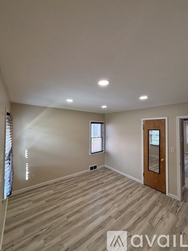 A room with wooden flooring and a window.
