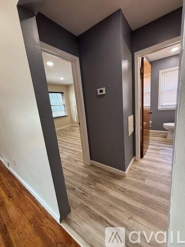 A room with wooden flooring and white walls.