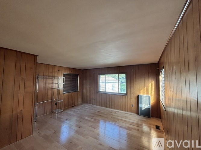 A room with wooden walls and a window.