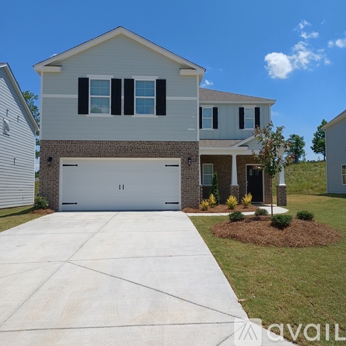 A two-story house with a garage and a driveway.