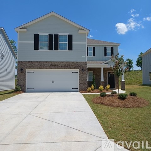 A two-story house with a garage and a driveway.