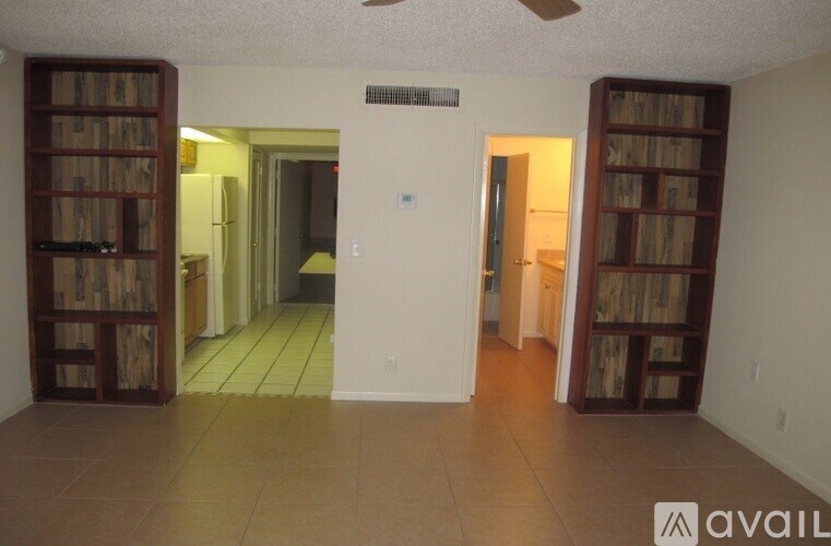 A room with a fan and bookshelves.