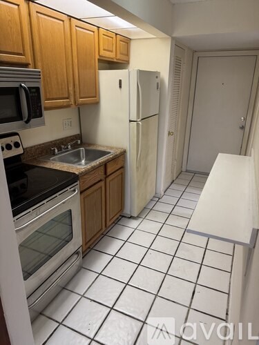 A kitchen with wooden cabinets and a white fridge.