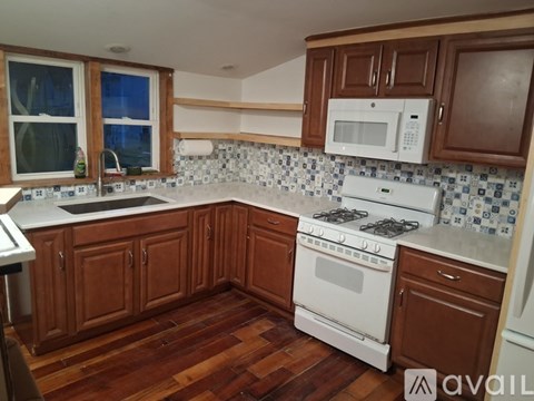 A kitchen with a white stove and refrigerator.