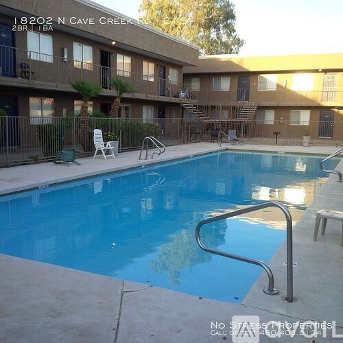 A swimming pool in front of a building with a sign that reads "NO STATES PROPERTY".