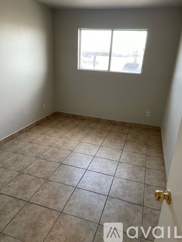 A room with tiled flooring and a window letting in light.