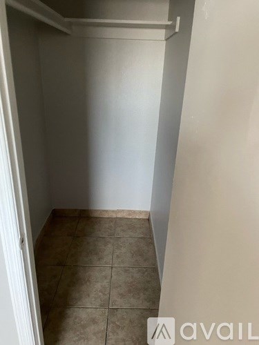 A small, empty room with tiled flooring and white walls.