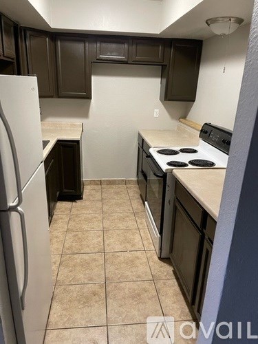 A kitchen with a white fridge and a white stove top oven.