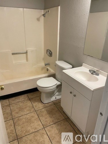 A white toilet and sink in a small bathroom.