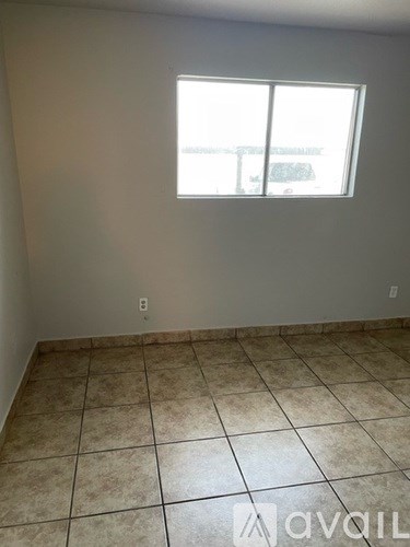 A room with a tiled floor and a window.