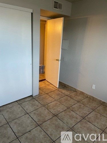A room with a tiled floor and a doorway leading to another room.