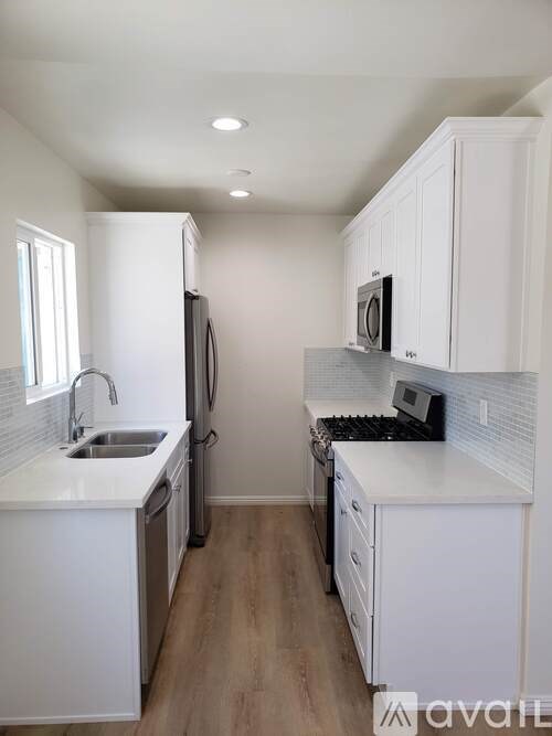 A kitchen with white cabinets and appliances.