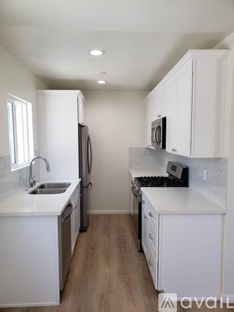 A kitchen with white cabinets and appliances.