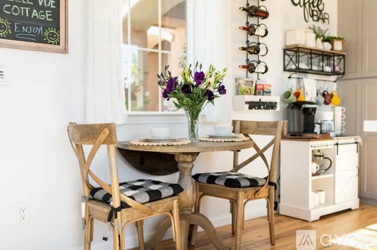 A dining room with a table set for two and a chalkboard sign on the wall.