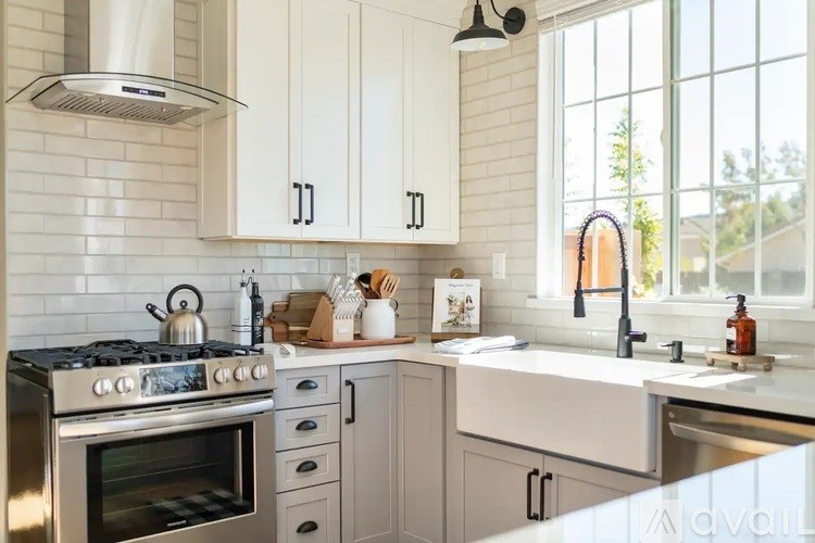 A kitchen with white cabinets and a stainless steel oven.