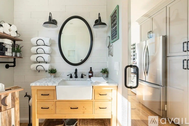A bathroom with a white sink and a round mirror.