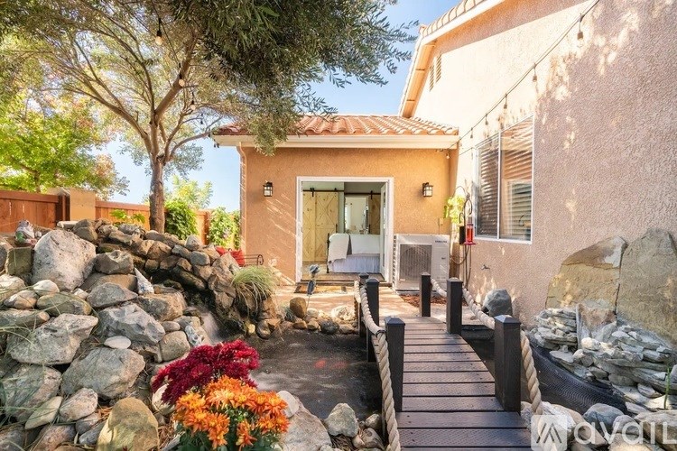 A small house with a brown door and a small garden in front.