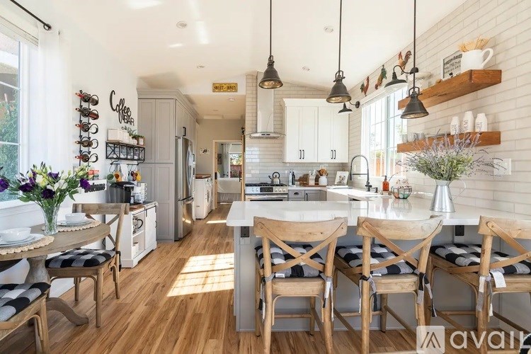 A kitchen with a dining table and chairs.