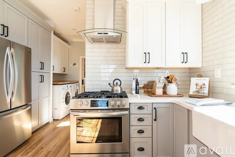 A modern kitchen with a stainless steel refrigerator and a stove top oven.