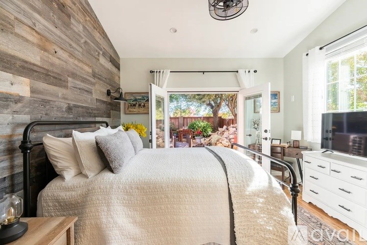 A bedroom with a large bed and a wooden wall.