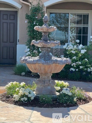 A stone fountain in the middle of a garden.