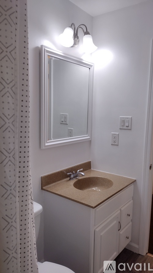 A bathroom with a sink, mirror, and toilet.