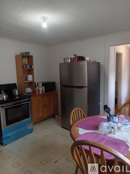 A kitchen with a blue fridge and a table with chairs.