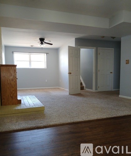 A room with a carpet, a ceiling fan, and a wooden podium.