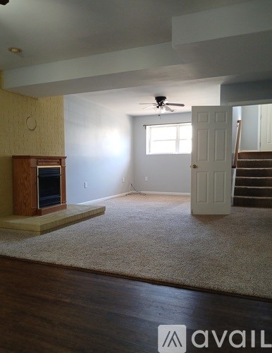 A living room with a fireplace and a rug on the floor.