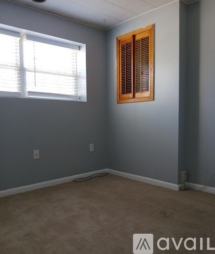 A room with a window and a wall socket.