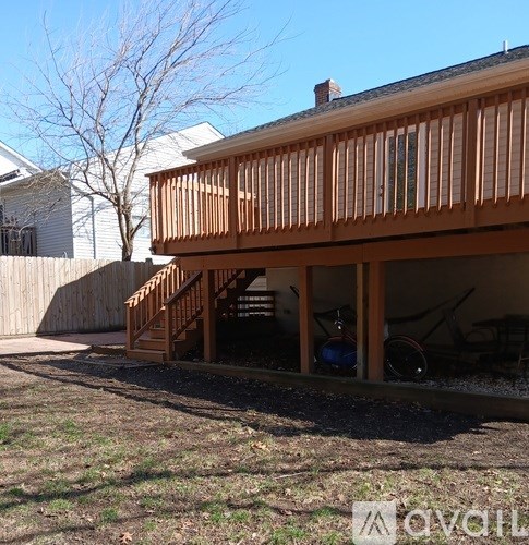 A wooden deck with a staircase leading to a house.