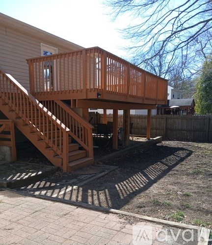 A wooden deck with stairs leading to a house.