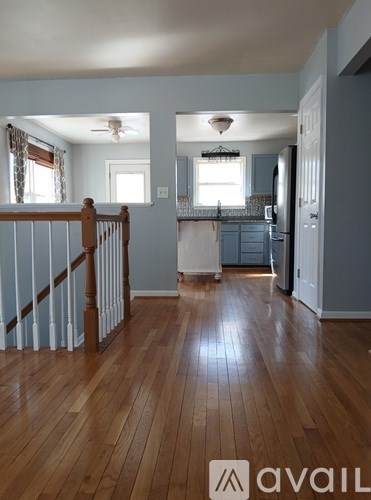 A kitchen with a refrigerator, cabinets, and a window.