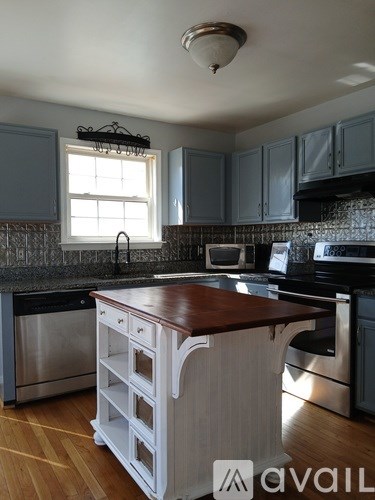 A kitchen with a wooden counter top and stainless steel appliances.