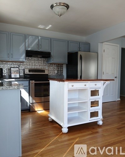A kitchen with a white island and stainless steel appliances.