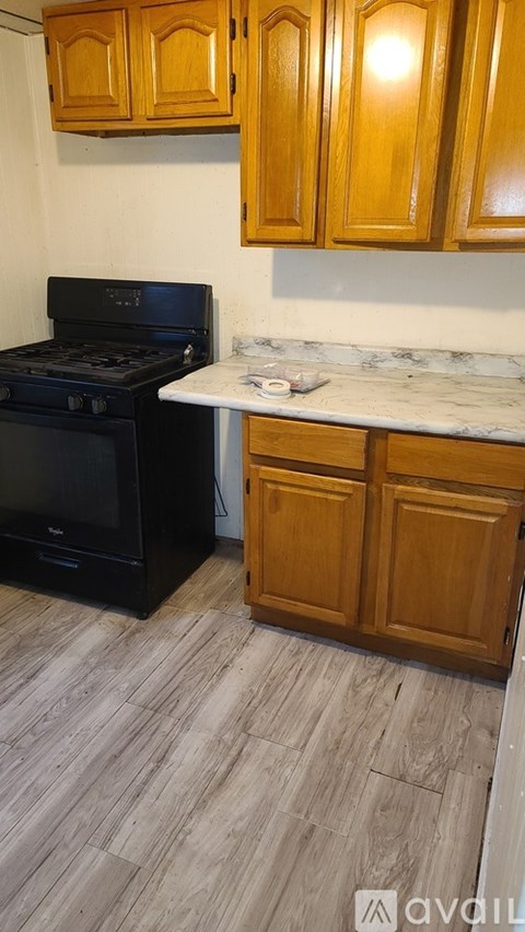 A kitchen with wooden cabinets and a black stove top oven.