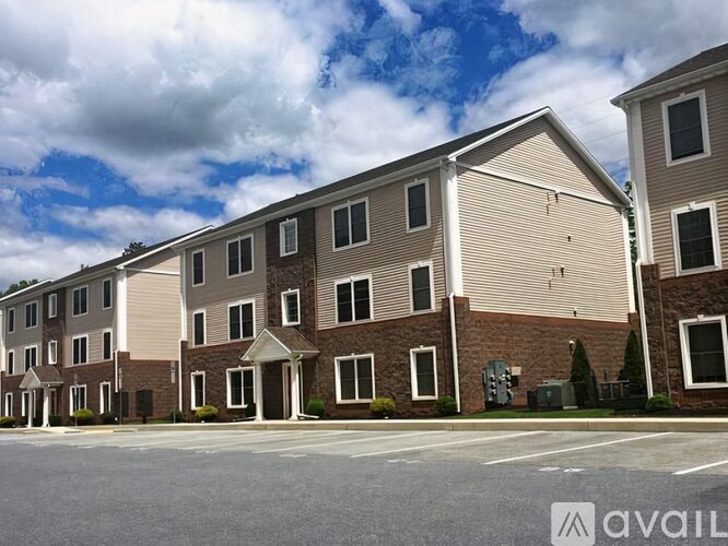 A row of townhouses with a cloudy sky in the background.