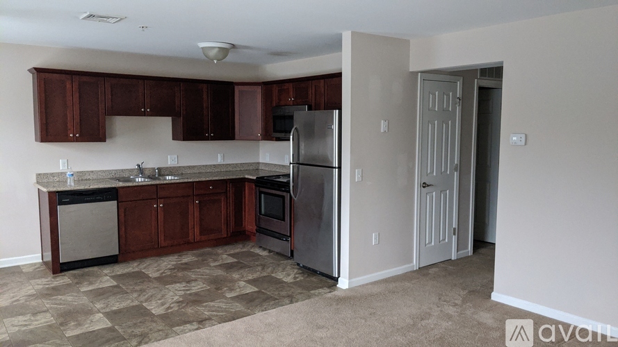 A kitchen with brown cabinets and a refrigerator.