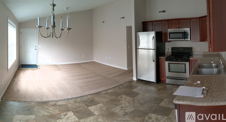 A kitchen with a refrigerator, oven, and microwave.