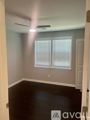 A room with a window and a fan on the ceiling.
