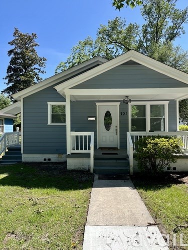 A small house with a white door and a porch.