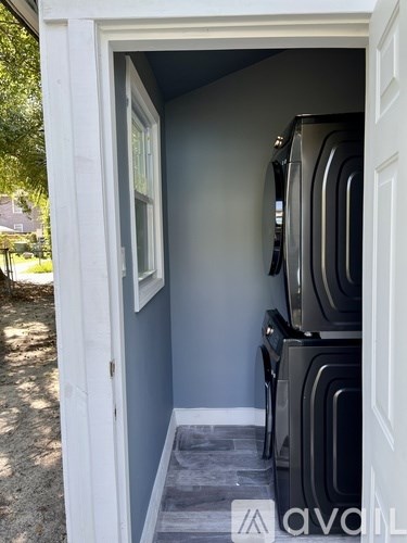 A small room with a washing machine and dryer stacked on top of each other.