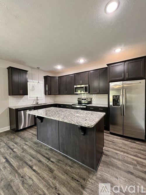 A kitchen with dark wood cabinets and stainless steel appliances.