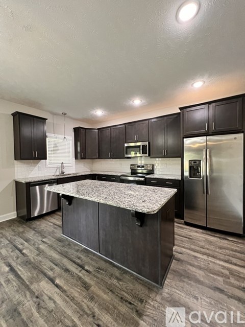A kitchen with dark wood cabinets and stainless steel appliances.