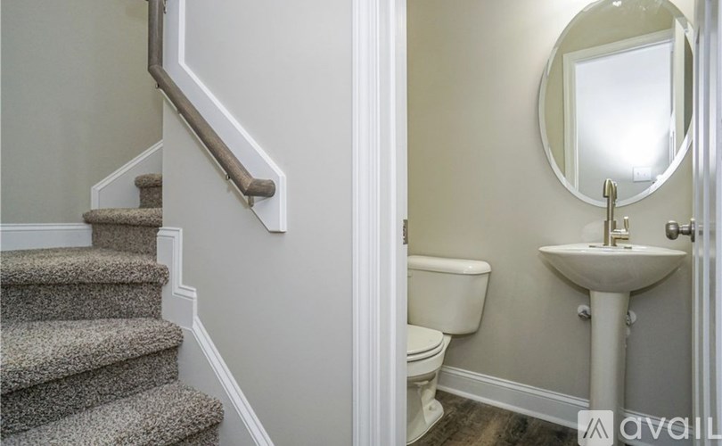 A bathroom with a sink, toilet, and stairs.