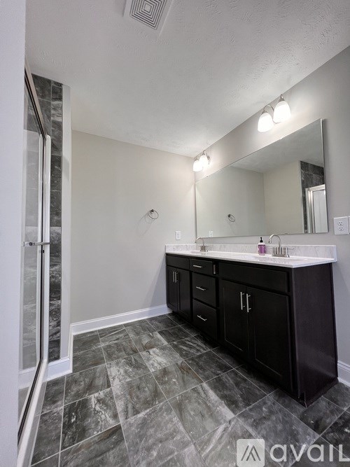 A bathroom with a sink, mirror, and cabinets.