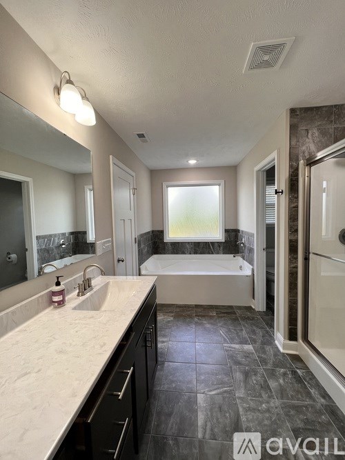 A bathroom with a marble floor and a large mirror.
